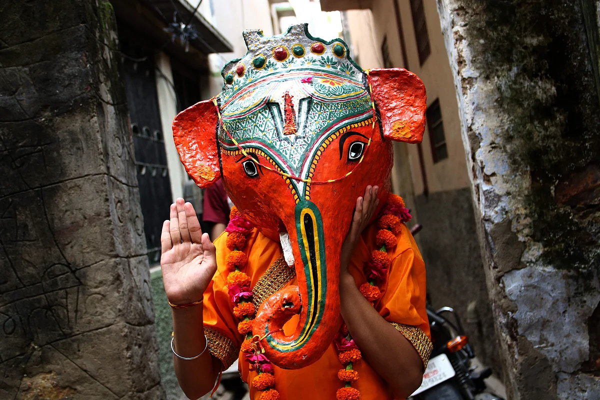 A boy dressed as the elephant-headed Hindu deity Ganesha gestures during Ganesh Chaturthi festival celebration in Pushkar