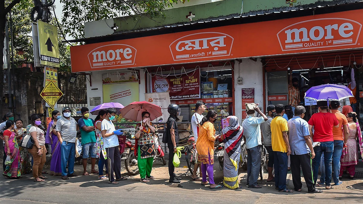 Locals stand in a queue to buy daily essentials before lock down amid rising concerns over the coronavirus pandemic, in Kolkata, Monday, March 23, 2020.