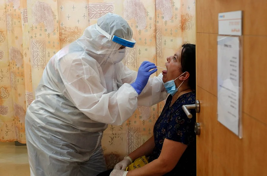 An Israeli medical worker takes a COVID-19 test sample at a medical clinic in central Israeli city of Ramla on June 18, 2020.