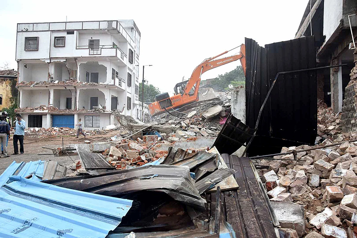 BMC workers raze illegal construction of a newspaper owner of a Hindi daily after unearthed a sex racket and booked the owner for the rape of a minor girl, in Bhopal on Tuesday.