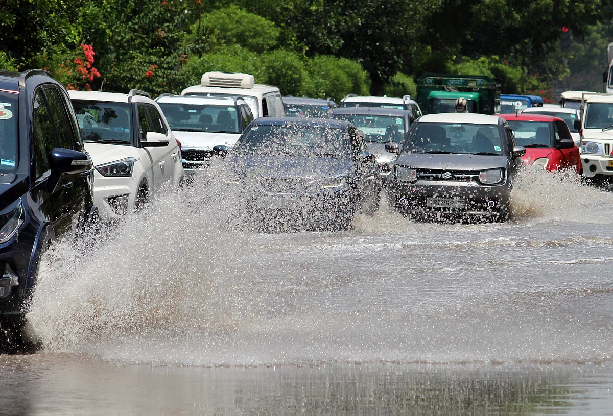 Vehicles wade through a waterlogged road after rain at near Unitech Cyber Park, in Gurugram on Thursday