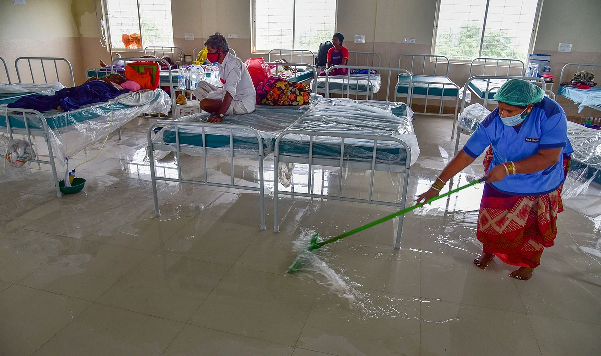 A worker clears rainwater collected inside one of the new wards of century-old Osmania General Hospital (OGH) building, in Hyderabad, Thursday, July 23, 2020. The Telangana government on Wednesday ordered the closure of Osmania General Hospital that was inundated with rain and sewerage water last week.