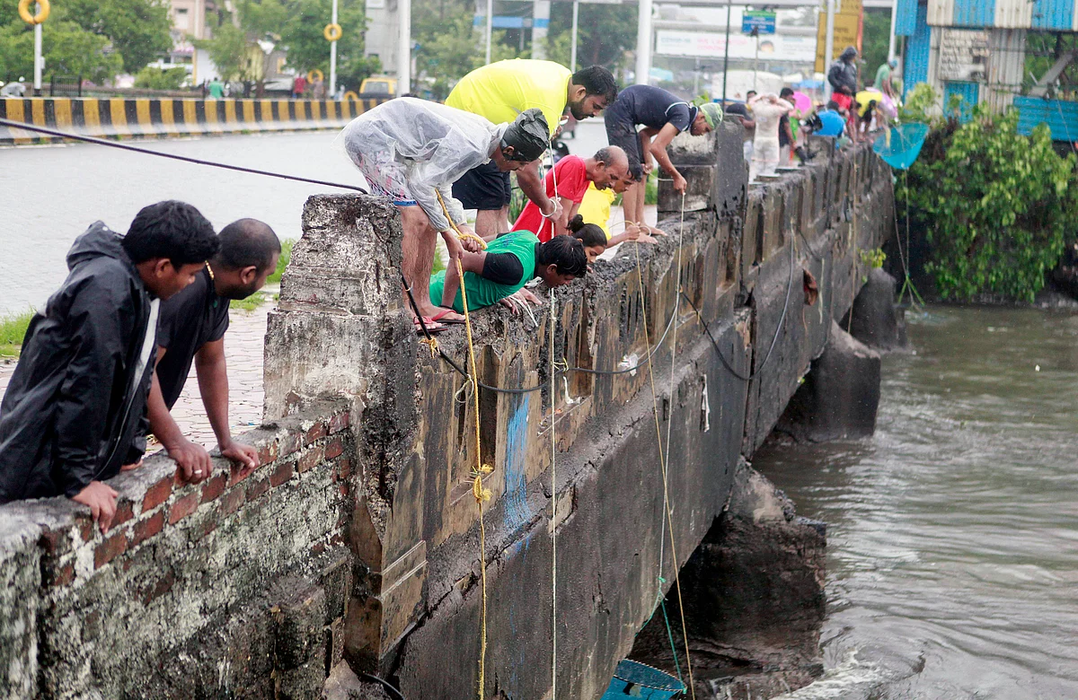 People fishing from bridge after heavy rainfall, at Mahim Creek in Mumbai on Sunday.
