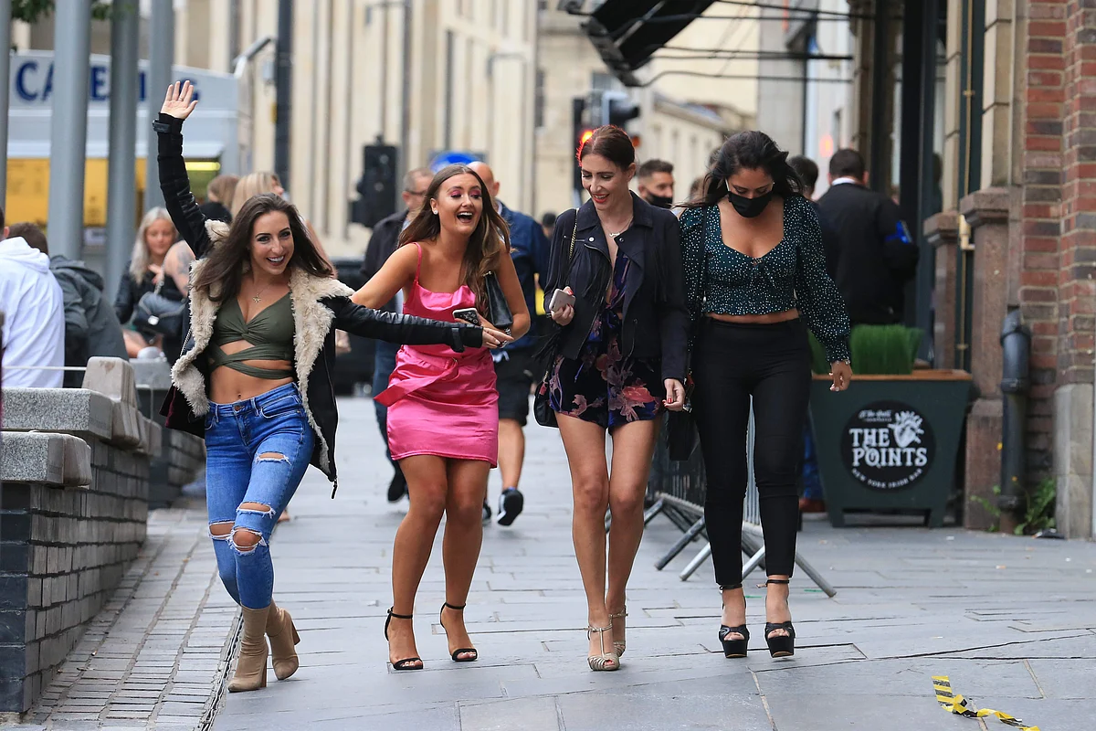 Women pose in the street on a night out in Newcastle, northern England on July 4, 2020, as restrictions are further eased during the novel coronavirus COVID-19 pandemic.