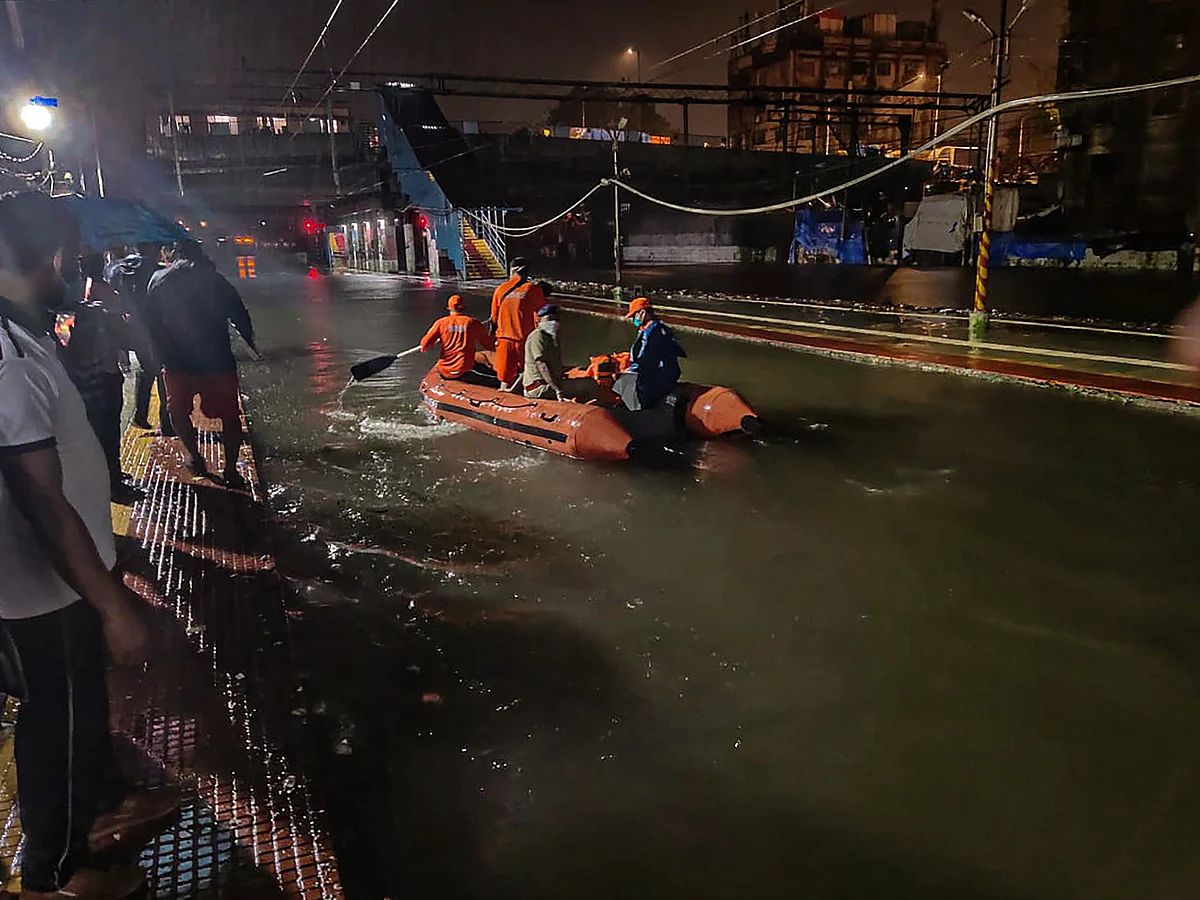National Disaster Response Force (NDRF) personnel rescue passengers from a local train stranded between Masjid Bunder and Byculla stations on the Central line, during heavy rain, in Mumbai, Wednesday, Aug. 5