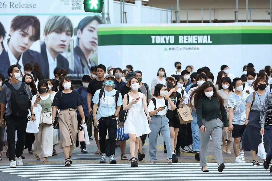 People wearing face masks walk on the street at Shibuya in Tokyo, Japan, on Aug. 20, 2020.