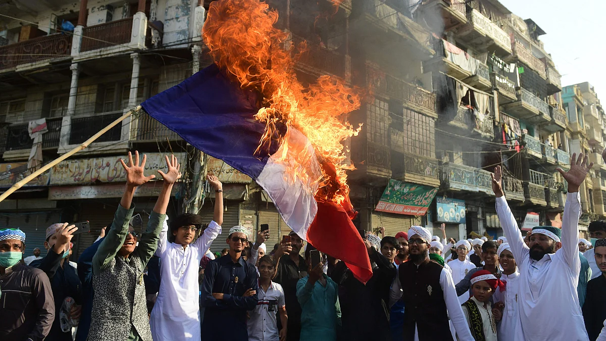 Pakistani Sunni Muslims burn a French flag during a protest in Karachi