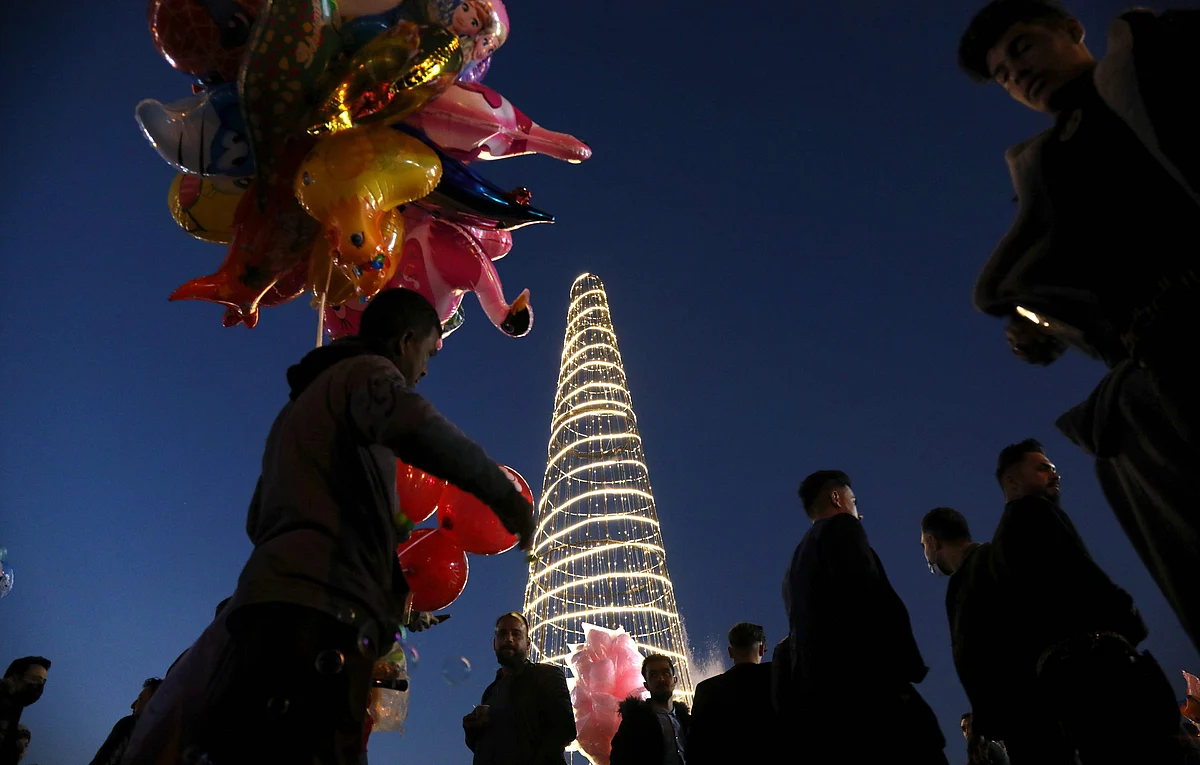 A man sells balloons as Iraqis gather around the citadel of Arbil, the capital of the autonomous Kurdish region of northern Iraq, to celebrate the new year on December 31, 2020.