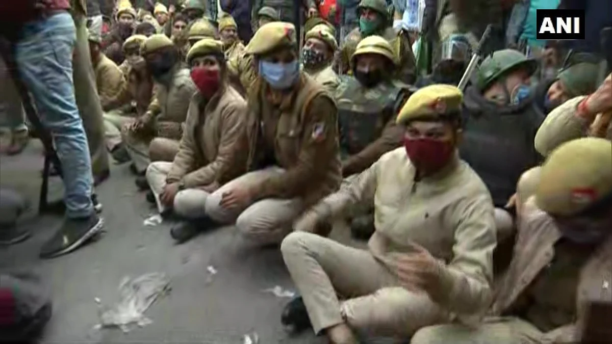 Delhi: Police officials sit on road in Nangloi to block the area
