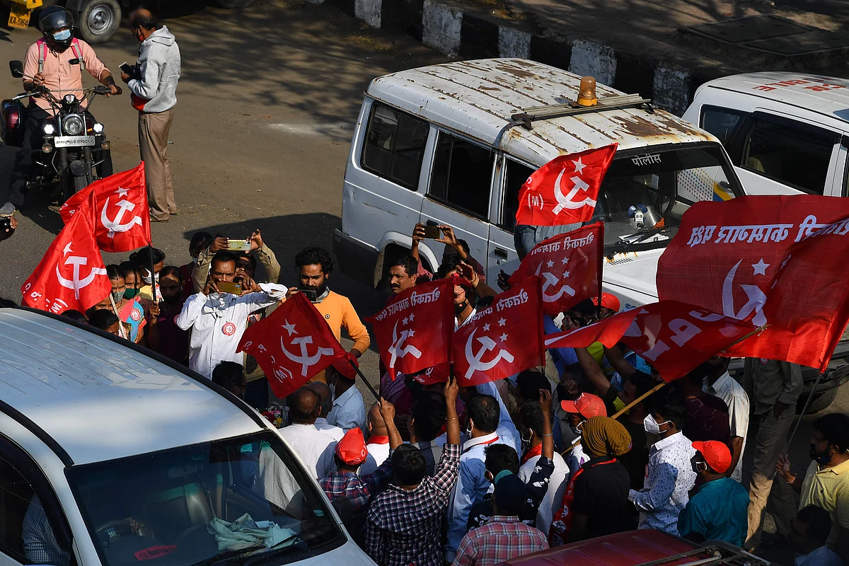 Passersby and members of the left-wing trade Union welcome farmers arriving after crossing a state highway during a rally in support of farmers who are continuing their protest against the central governments recent agricultural reforms, at Bhiwandi in the Thane district of Maharashtra on January 24, 2021.