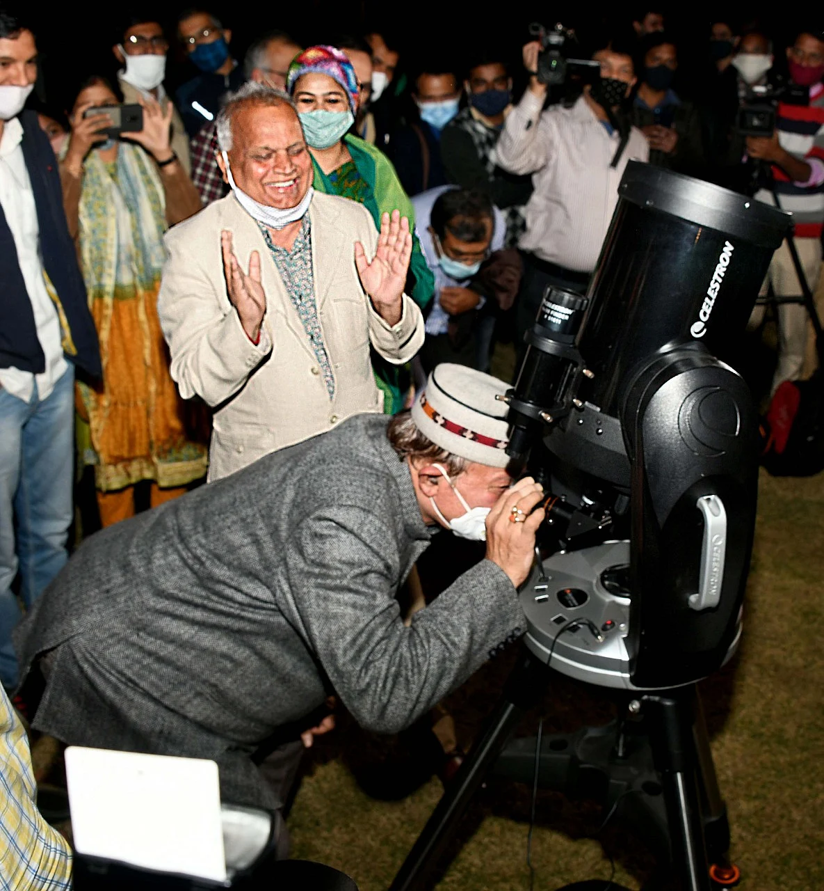 Art and Culture minister Dr. B.D. Kalla looking at the night sky through the telescope. To this left, chief secretary Niranjan Arya.