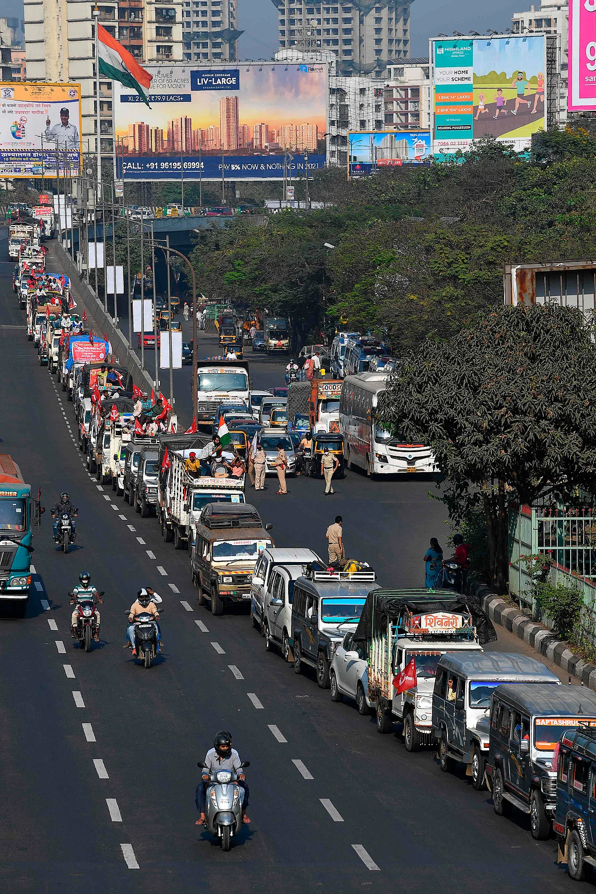 Farmers in vehicles cross a state highway during a rally to Mumbai in support of the ongoing farmers protest against the central governments recent agricultural reformson, at Bhiwandi in the Thane district of Maharashtra on January 24, 2021