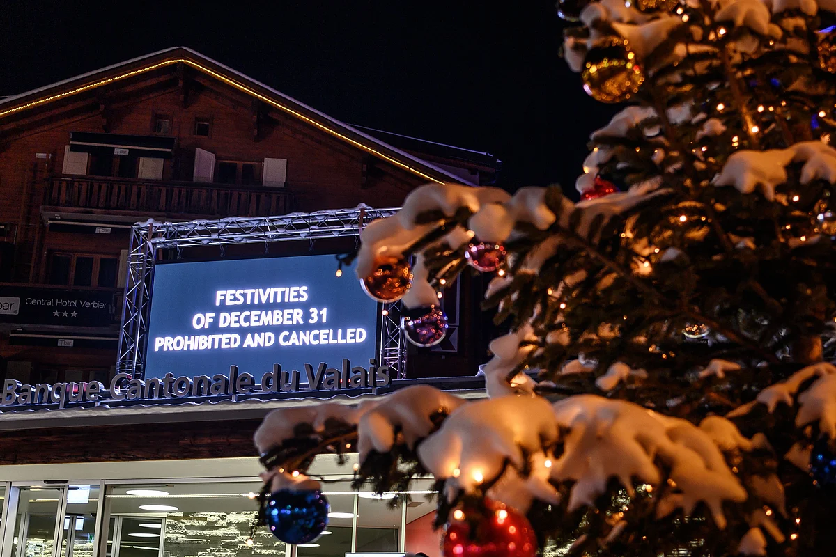 A board is seen at the centre sqaure of the Swiss Alpine resort of Verbier to prevent people from gathering for the New Year on late December 31, 2020.