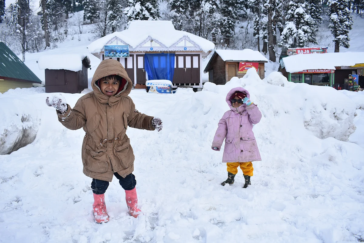 Children throw snowballs on each other on the snow-covered Ski Resort Gulmarg during a sunny winter day, on Tuesday.