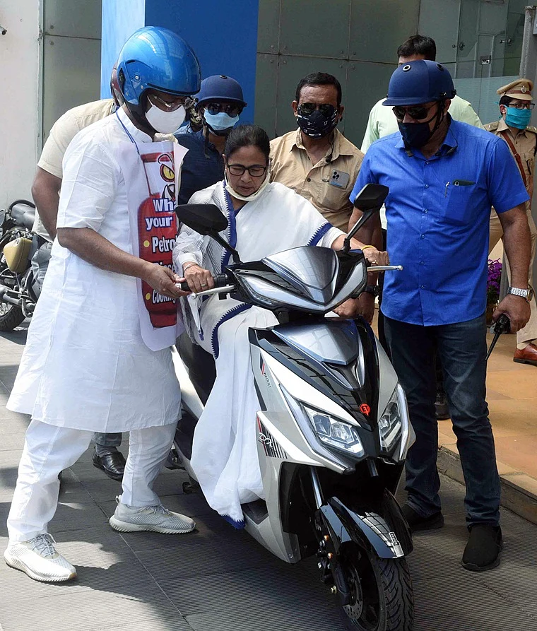 Chief Minister Mamata Banerjee along with Mayor of Kolkata Firhad Hakim rides an electric scooter as a mark of protest against rising fuel prices, in Kolkata