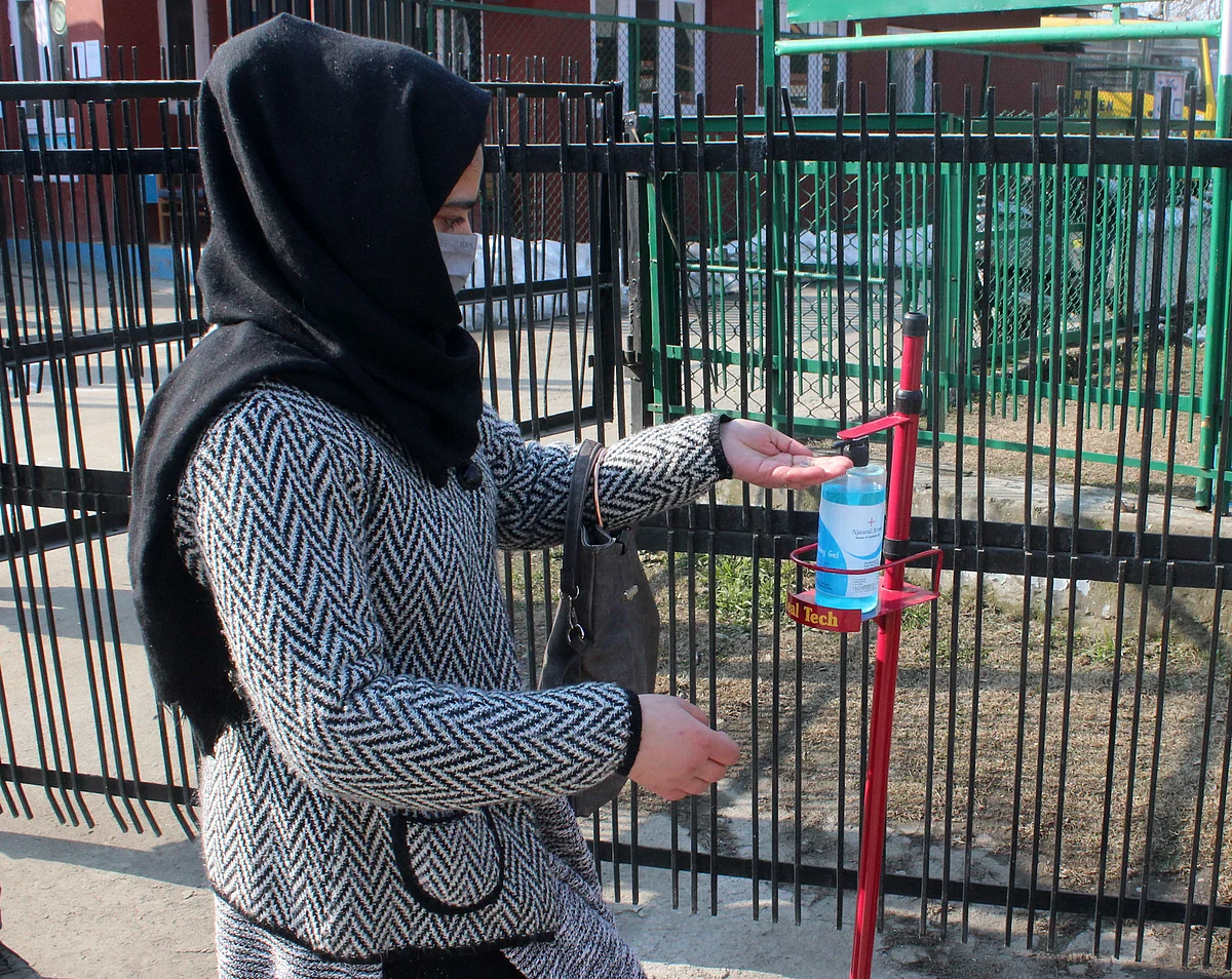 Students sanitise their hands before enter to a College as colleges reopened after more than 11-months closure due to the Covid-19 coronavirus pandemic in Srinagar, Kashmir.