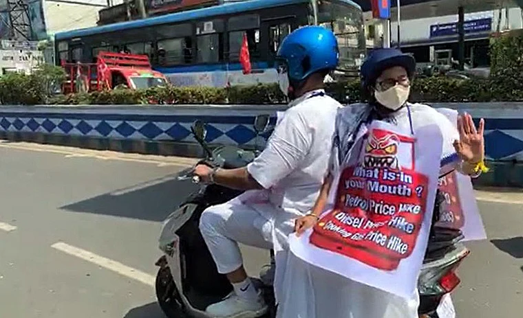 With a placard protesting against the petrol price hike hanging around her neck, helmet-clad Banerjee waved at people on both sides of the road