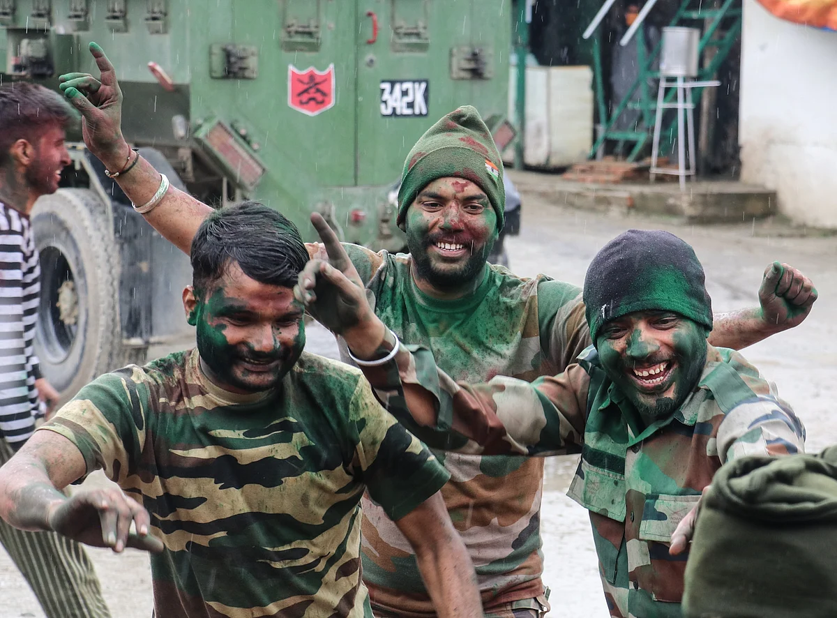 Indian army troopers, smeared in colour, dance during Holi celebrations at their camp on the outskirts of Srinagar, Kashmir.