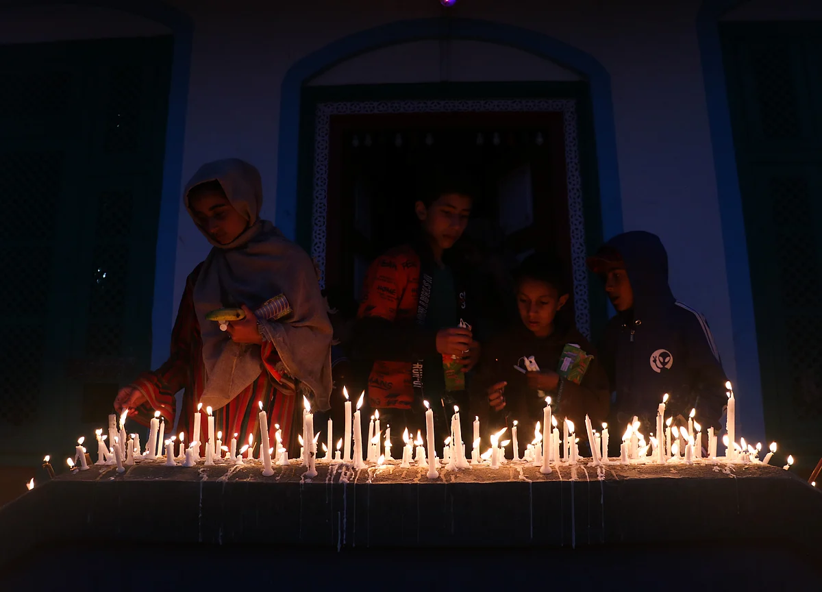 Kashmiri Shiite Muslims pray as they light candles at a graveyard to mark Shab-e-Barat on the outskirts of Srinagar, Kashmir.