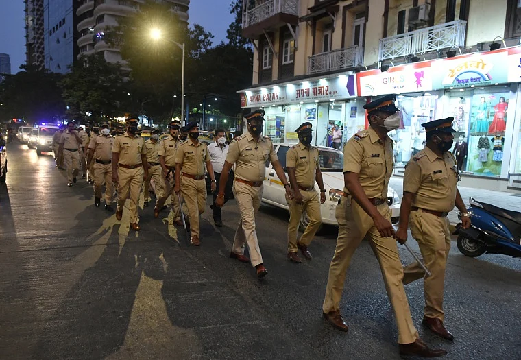 Police personnel conduct a flag march during night curfew, imposed by the authorities to curb the spread of coronavirus, in Mumbai