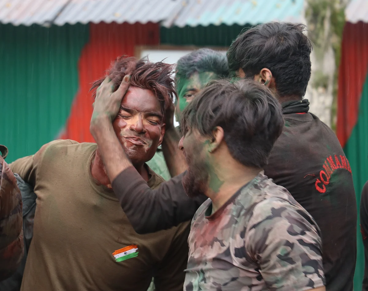 Indian Army soldiers celebrate Holi inside their base camp on the outskirts of Srinagar on March 29, 2021, in Kashmir.