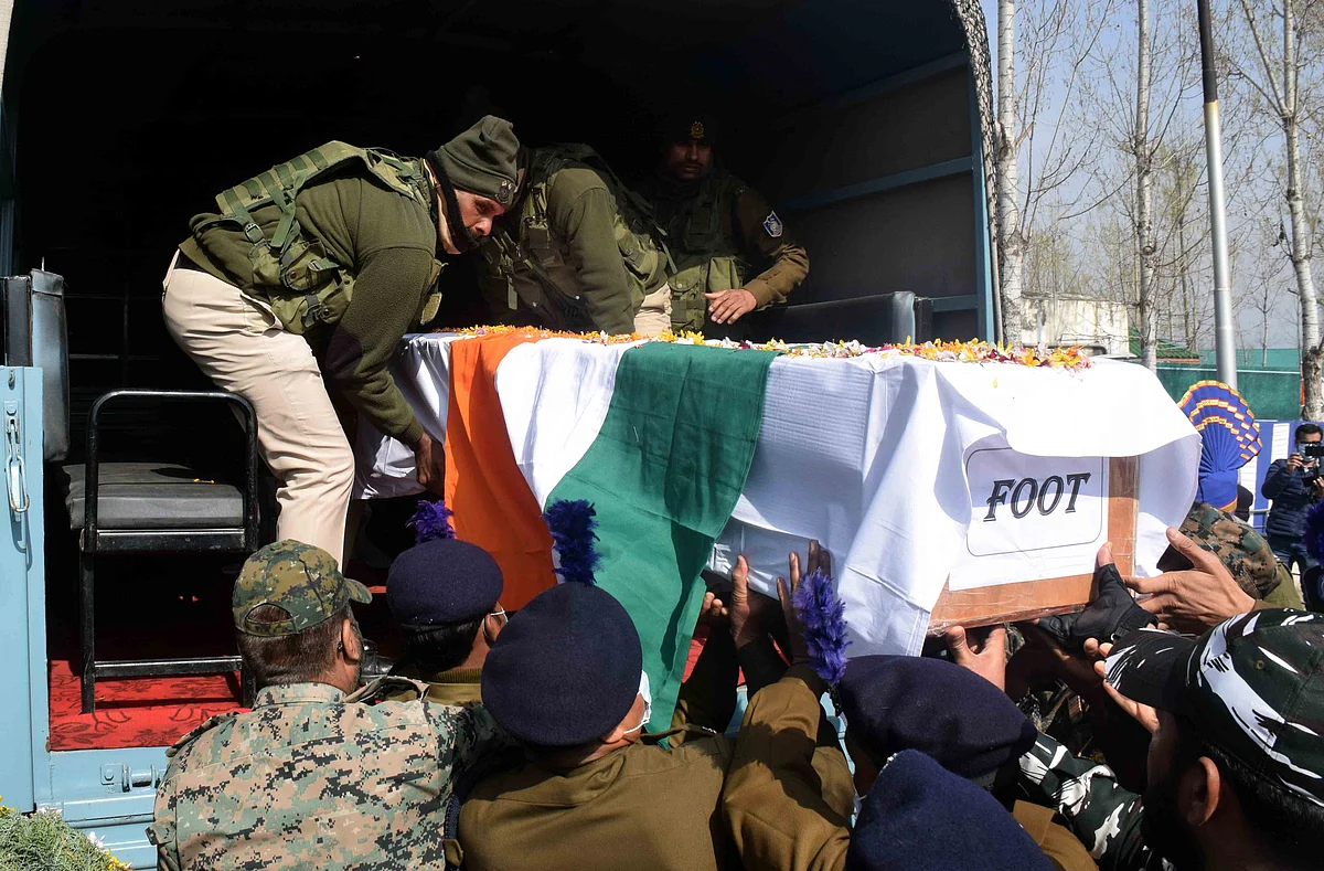 CRPF and police officers are getting coffins of slain CRPF men into a vehicle on Friday, March 26, 2021.