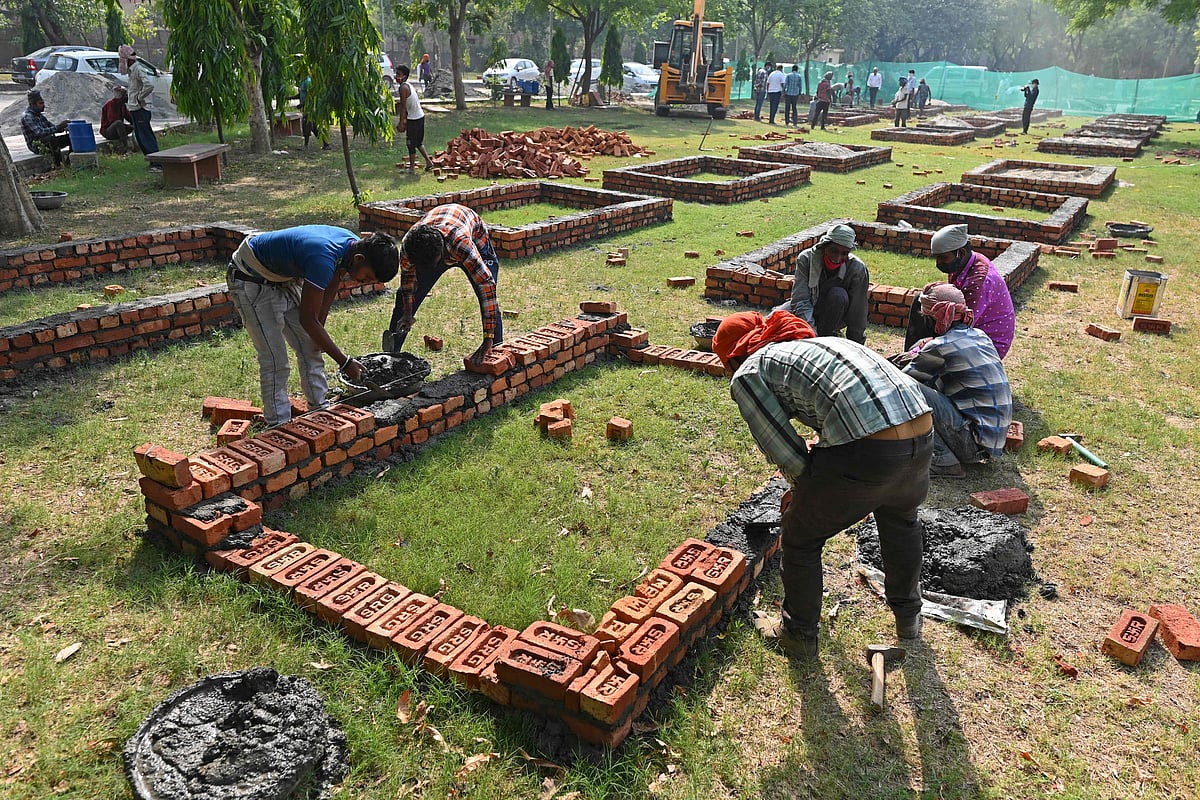 Workers are seen constructing makeshift platforms for funeral pyres inside the premises of a crematorium in New Delhi on April 27, 2021