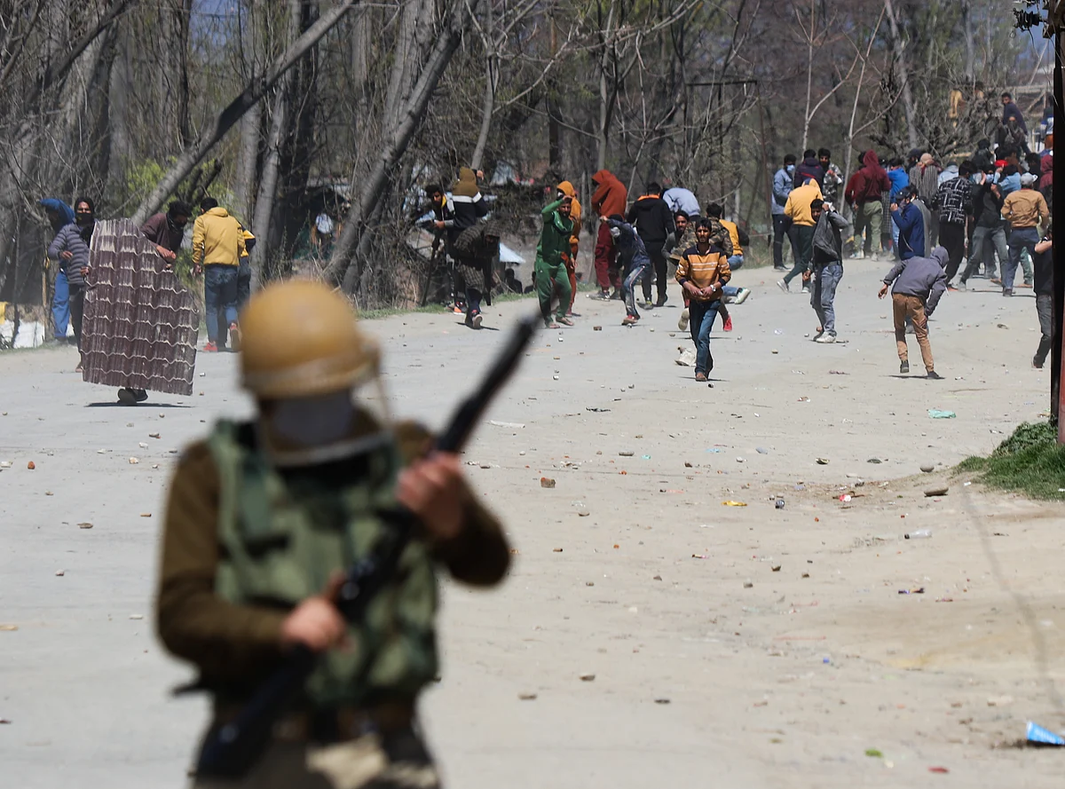 Kashmiri protesters throw stones towards the government forces during the clashes near the site of the gunfight in the Pulwama district of South Kashmir.