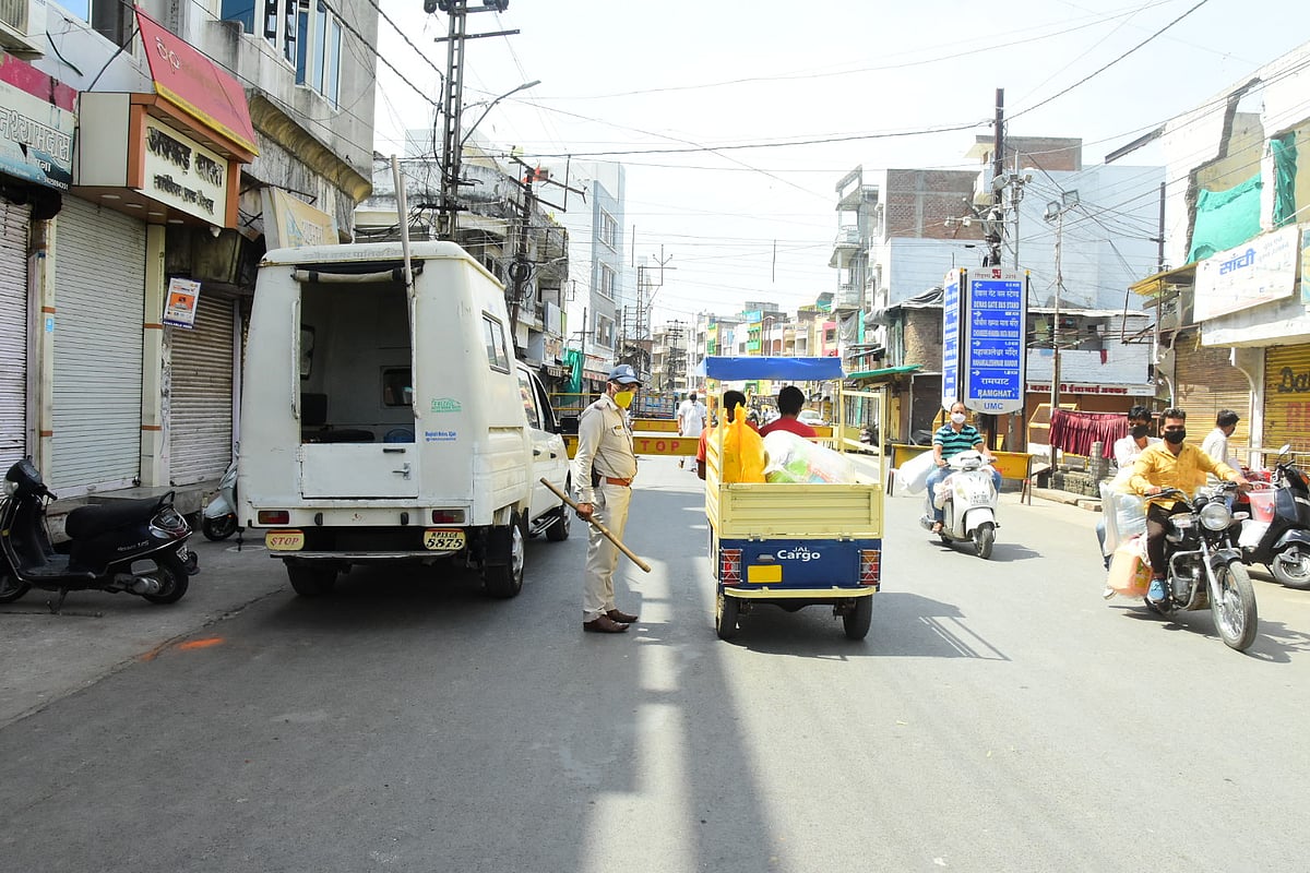 People carry sacks of grocery items from wholesale markets in Daulatganj-Favvara Chowk in Ujjain on Friday
