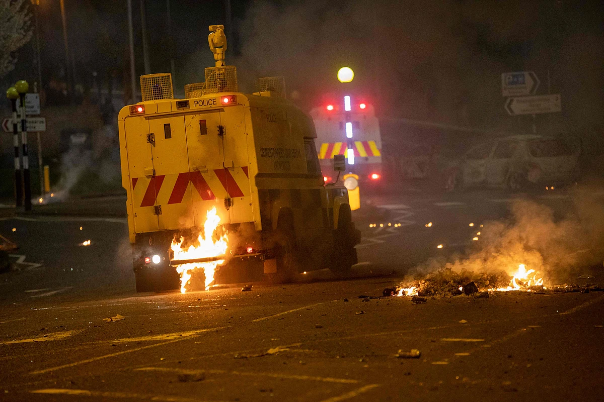 Flames are seen at the rear of a police vehicle after violence broke out in Newtownabbey, north of Belfast, in Northern Ireland on April 3, 2021