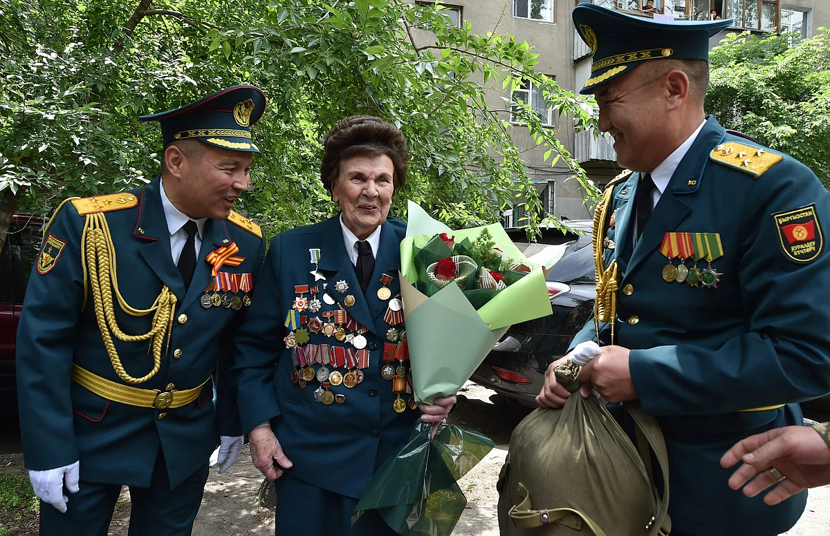 World War Two veteran Valentina Kosatyh, 96, receives congratulations from Kyrgyz servicemen during the Victory Day celebrations in Bishkek, Kyrgyzstan on May 9, 2021