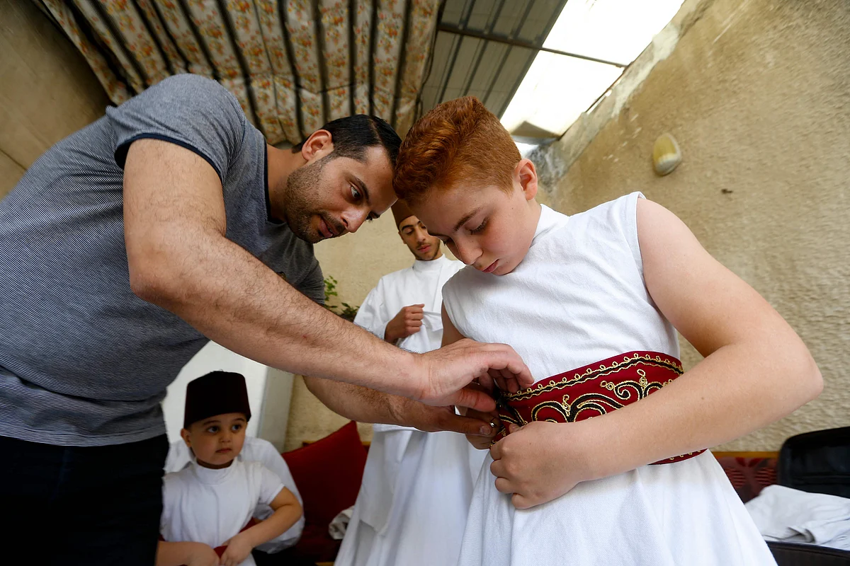 Sufi Dervish dancers of the Kharrat family don their costumes at their home in the Shahgur district of the old city of Syrias capital Damascus on May 6, 2021.