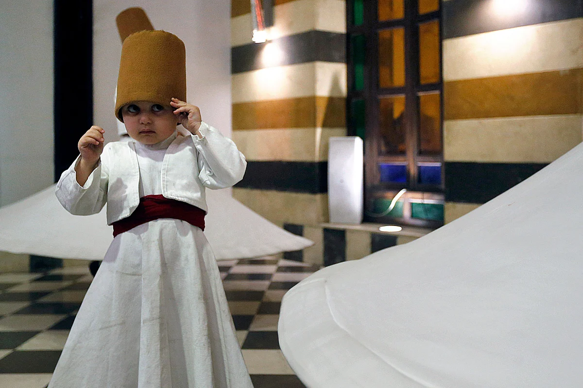 Three-year-old Sufi Dervish dancer Anas al-Kharrat dances with his family members at a restaurant in the Shahgur district of the old city of Syrias capital Damascus on May 5, 2021.