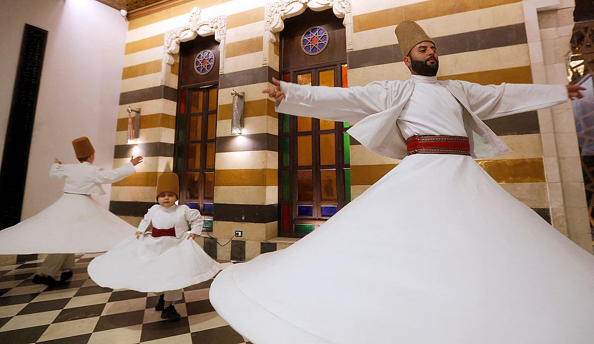 (L to R) Sufi Dervish dancers Yasser, Anas, and Muayad al-Kharrat, members of the Kharrat family, dance at a restaurant in the Shahgur district of the old city of Syrias capital Damascus on May 5, 2021.