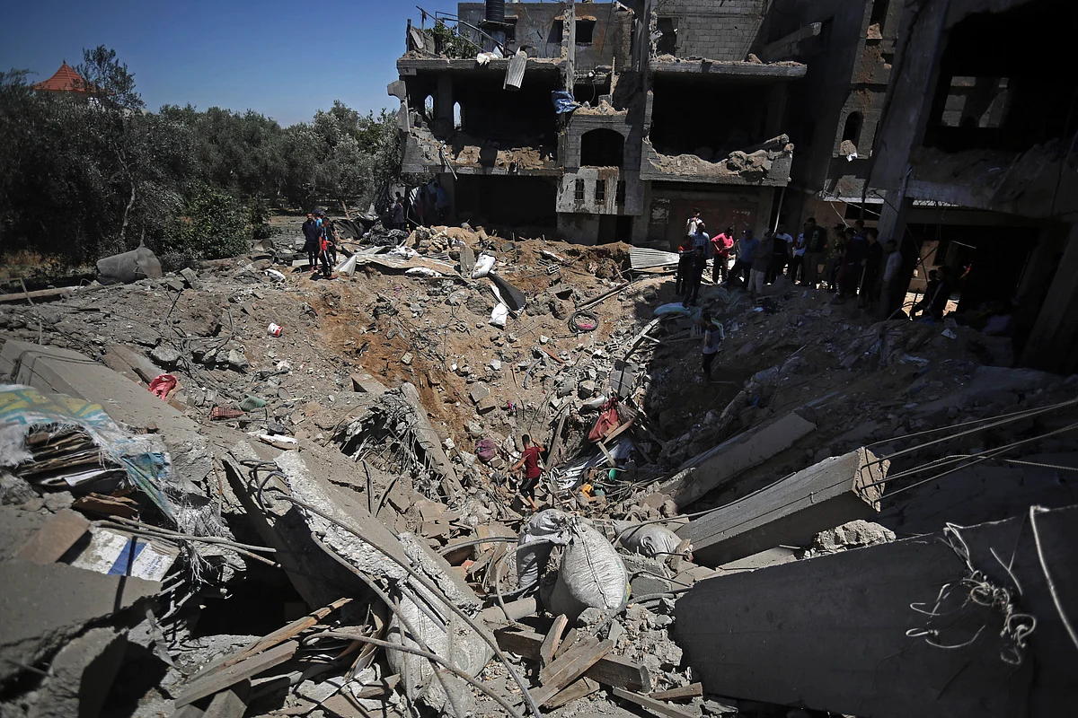 Palestinians inspect the damage of a destroyed house that was hit by an Israeli airstrike in the town of Khan Younis, southern Gaza Strip, Wednesday