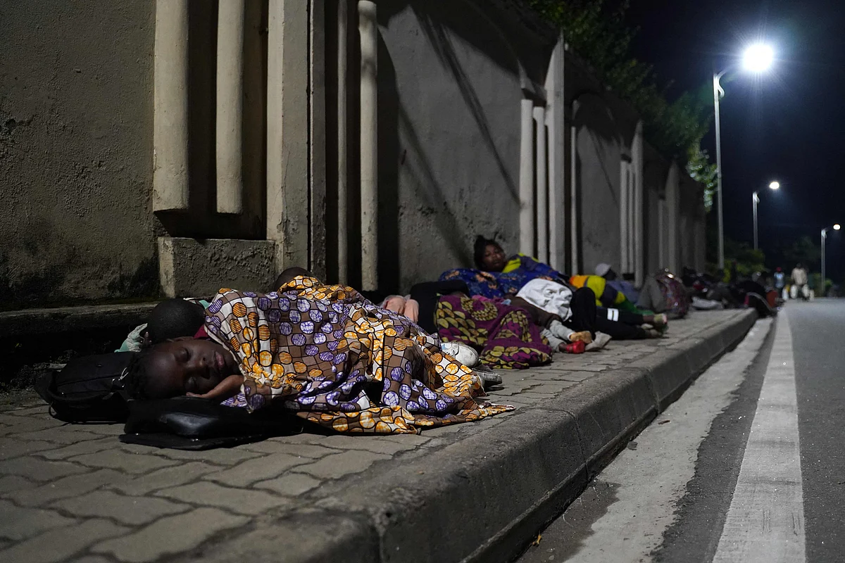 Congolese fleeing from Goma, Democratic Republic of Congo (DRC), sleep with their belongings on a street after the Nyiragongo volcano erupted near the border in Gisenyi, Rwanda, on May 23, 2021