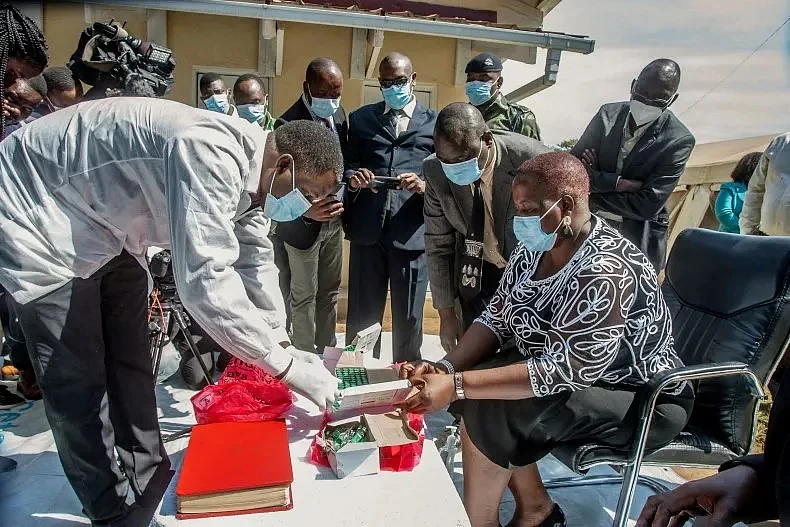 A pharmaceutical expert (L) opens a pack of expired COVID-19 Astra Zeneca vaccines to show to Malawi’s Health Minister Khumbize Kandodo Chiponda (R) before they are destroyed in a furnace at a pharmaceutical incinerator at Kamuzu Central Hospital in Lilongwe on May 19, 2021