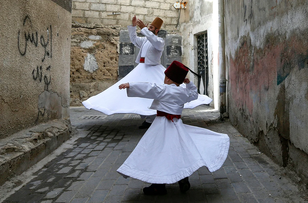 Sufi Dervish dancer Muayad al-Kharrat (behind), 28, dances with his three-year-old son Anas (front) by their home in the Shahgur district of the old city of Syrias capital Damascus on May 6, 2021.
