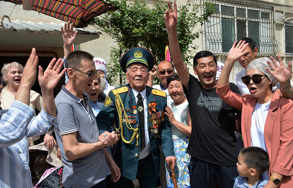 World War Two veteran Asek Urmanbetov, 98, receives congratulations from Kyrgyz servicemen during the Victory Day celebrations in Bishkek, Kyrgyzstan on May 9, 2021.