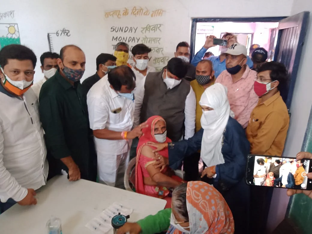 MP Anil Firojia encourages people in Malikhedi to get vaccinated.