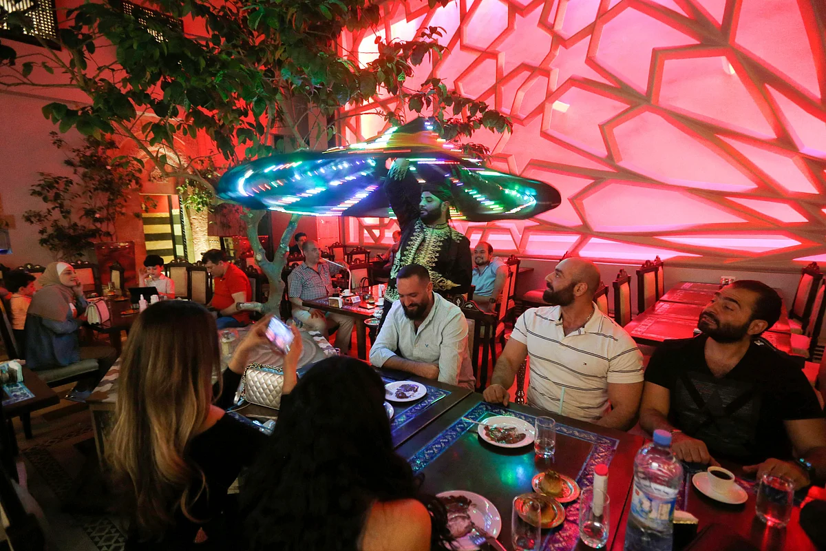 Sufi Dervish dancer Muayad al-Kharrat, 28, dances with his lit dress at a restaurant in the Shahgur district of the old city of Syrias capital Damascus on May 5, 2021.