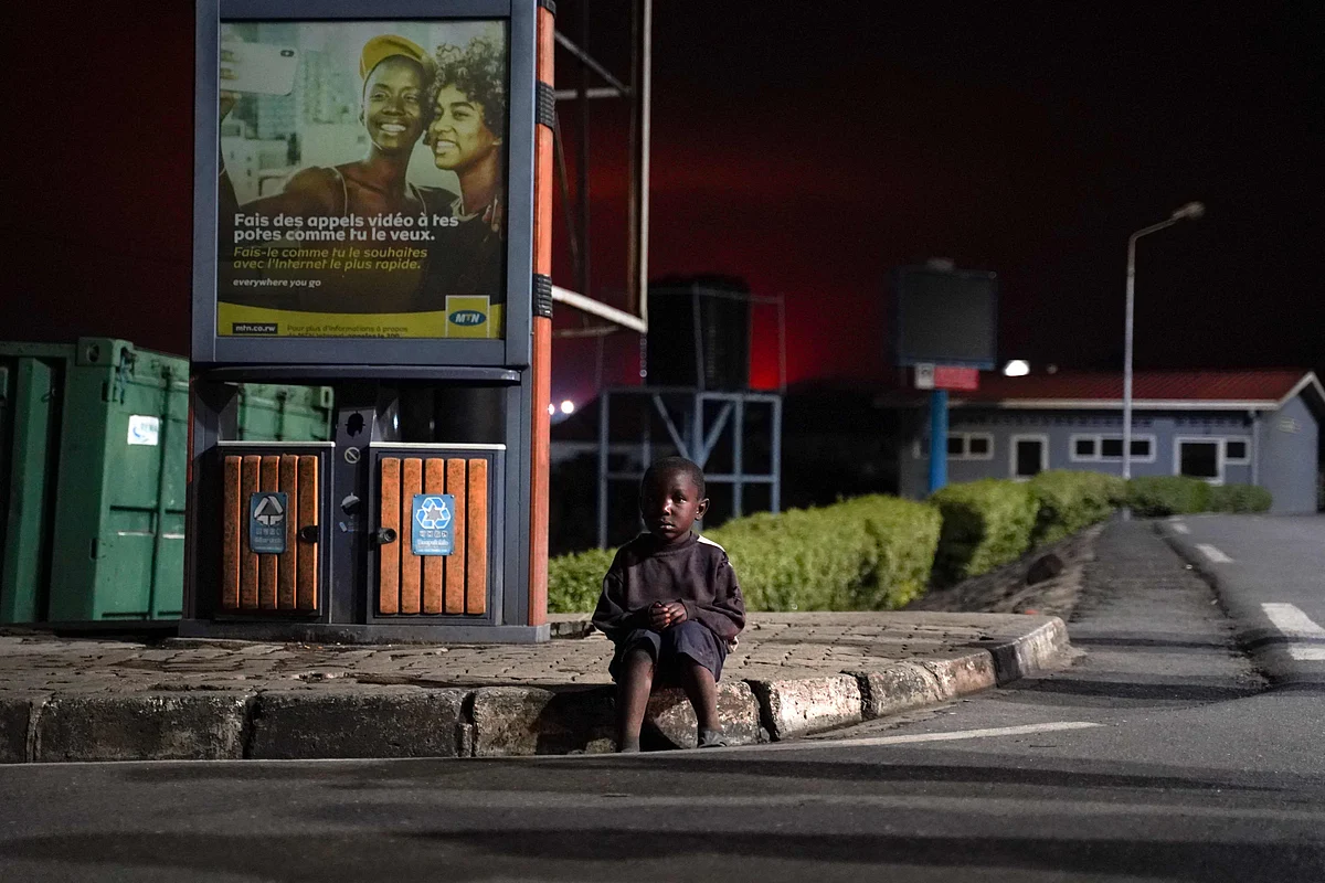 A lost child sits on a curb as Congolese people flee from Goma after the Nyiragongo volcano erupted, at the border point known as "Petite Barriere" in Gisenyi, Rwanda, on May 23, 2021.