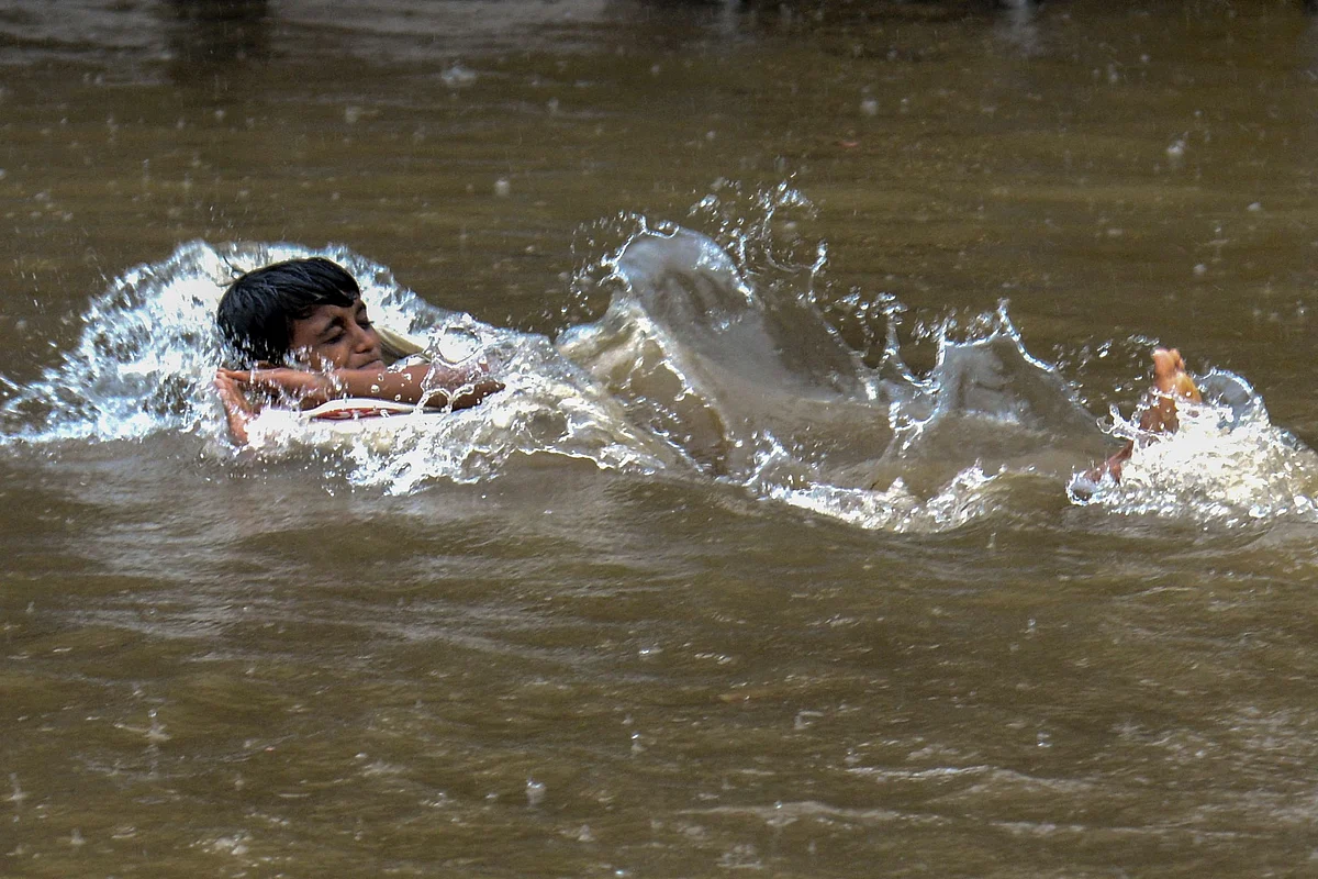 A boy swims in a waterlogged street following a heavy monsoon rainfall in Mumbai on June 9, 2021.