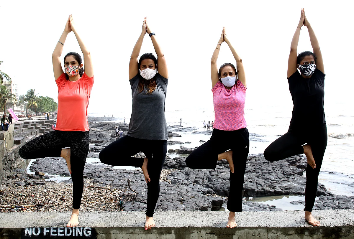 A group of girls performs yoga, on the occasion of the 7th International Yoga Day, at Bandra Bandstand, in Mumbai on Monday.