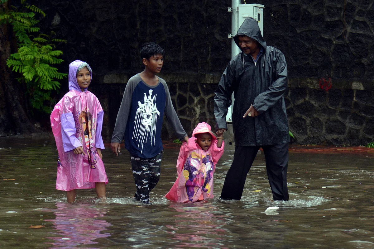 A family wades along a waterlogged street following a heavy monsoon rainfall in Mumbai on June 9, 2021.