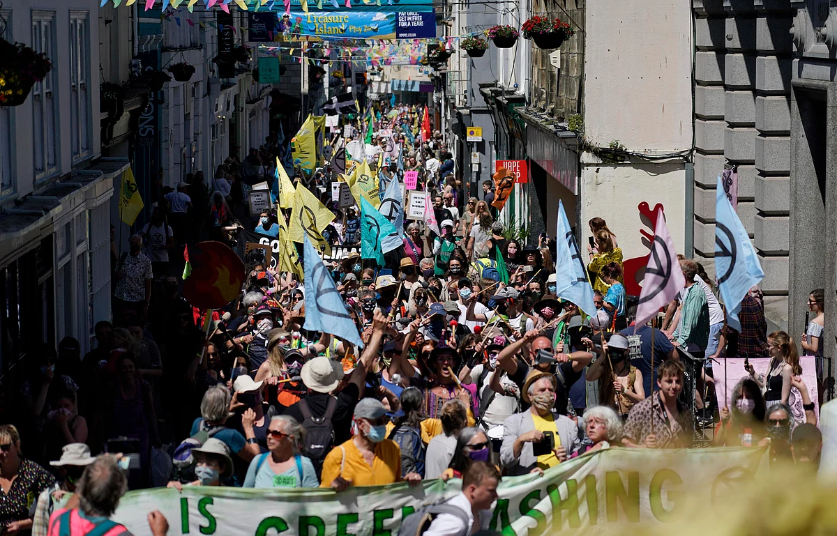 Activists march through the streets in during a demonstration around the meeting of the G7 in Falmouth, Cornwall, England, Saturday, June 12, 2021. Leaders of the G7 gather for a second day of meetings on Saturday, in which they will discuss COVID-19, climate, foreign policy and the economy.