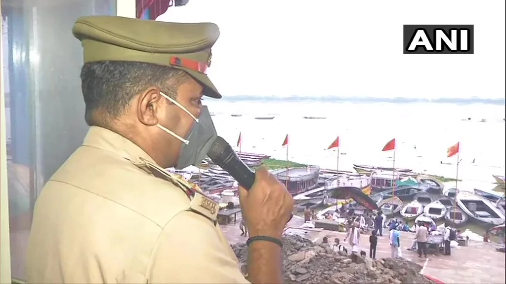 Police personnel deployed at Ganga Ghat on the occasion of the Ganga Dussehra festival, made repeated announcements to adhere to Covid-19 protocols in Varanasi, Sunday, June 20, 2021.