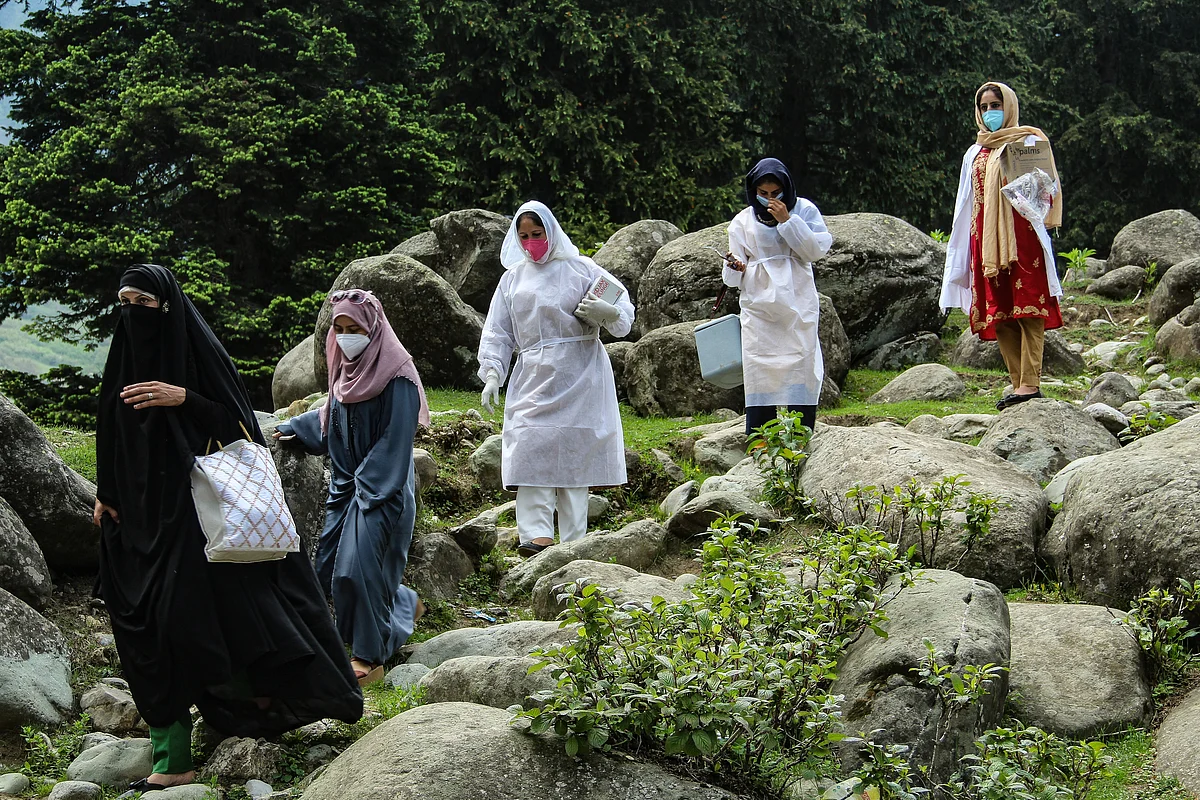 Healthcare workers head to a hut to inoculate nomadic tribes during a COVID-19 vaccination drive in the forest area of Central Kashmir's Budgam district.