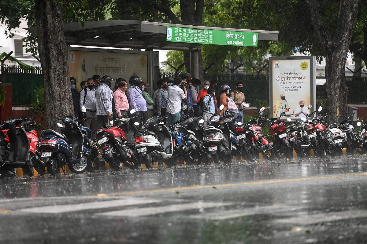 Commuters shelter on a bus stop during a monsoon rainfall in New Delhi on June 17, 2021.