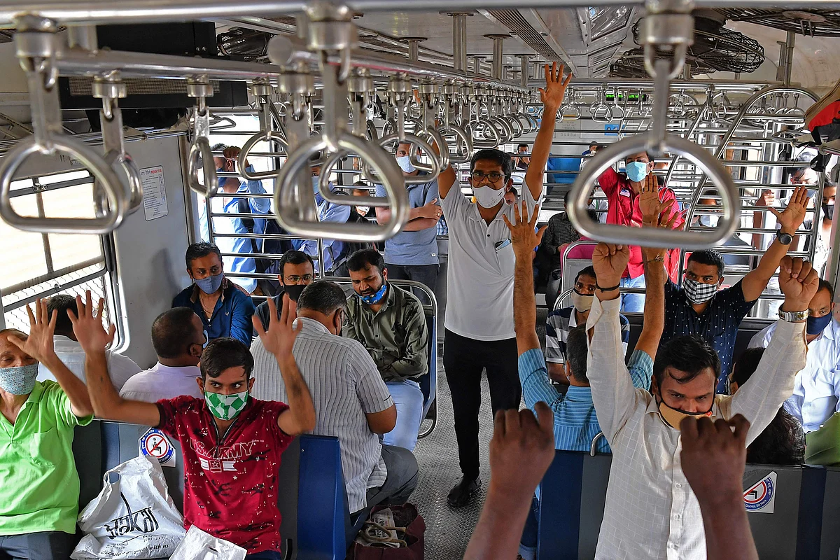 Commuters take part in a yoga session inside a train coach in Mumbai on June 21, 2021, to mark International Yoga Day.